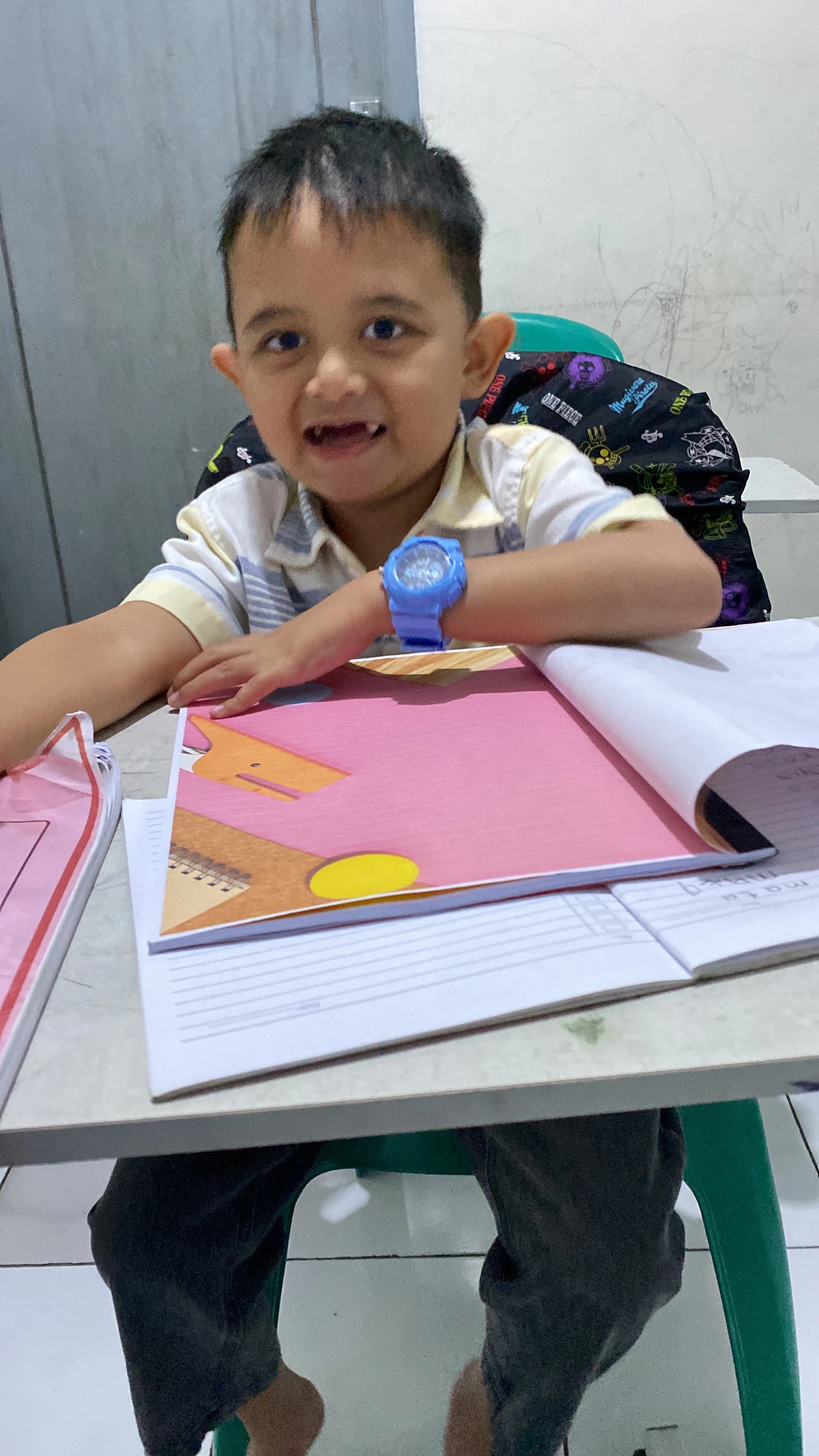 Anak membaca buku cerita sendiri di rumah